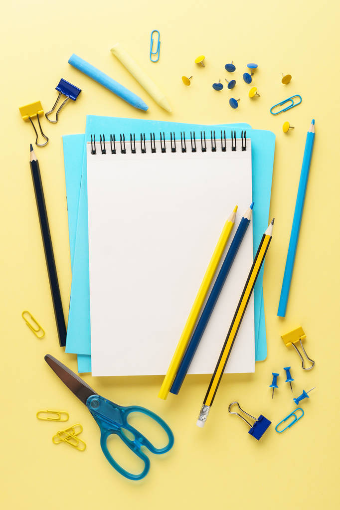 Школьный блокнот и различные синие и желтые канцтовары
. - Фото, изображение