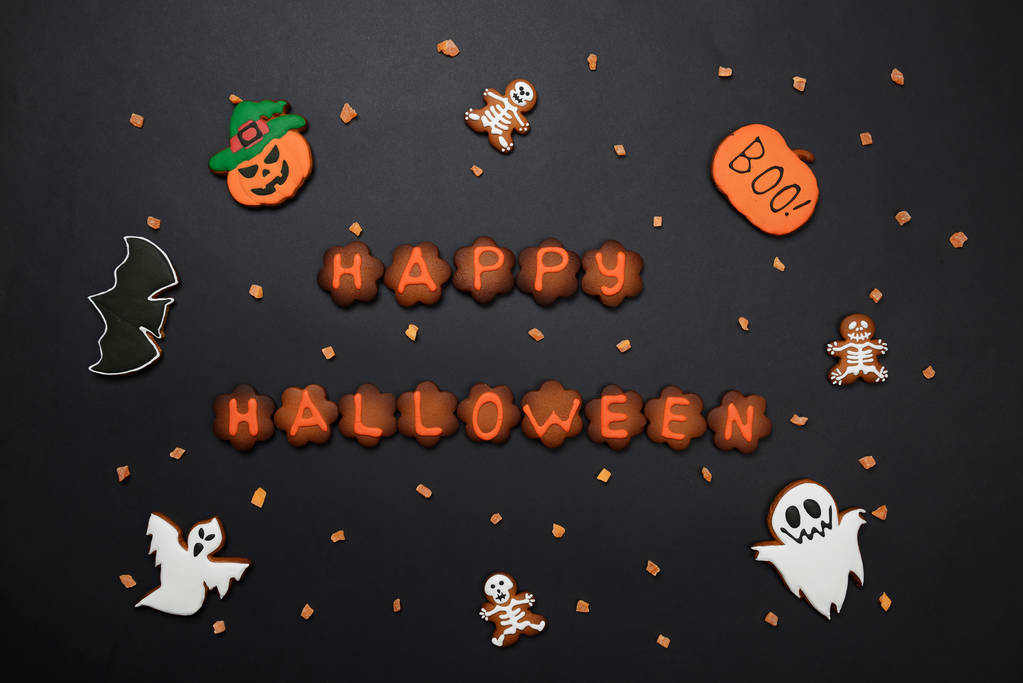A kézi ehető mézeskalács Halloween felirat, sütőtök, szellemek, denevér és sceletons fekete háttér - Fotó, kép