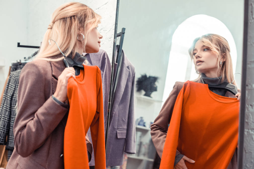 Mujer rubia mirando en el espejo en el centro comercial
 - Foto, Imagen