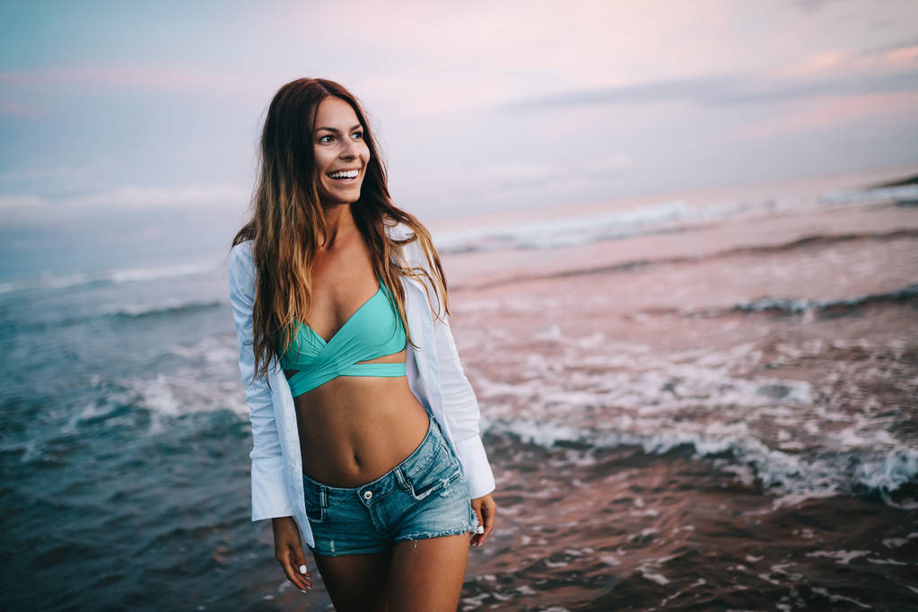 Kaunis tyttö rannalla auringonlaskun aikaan. Kesäloma käsite
 - Valokuva, kuva