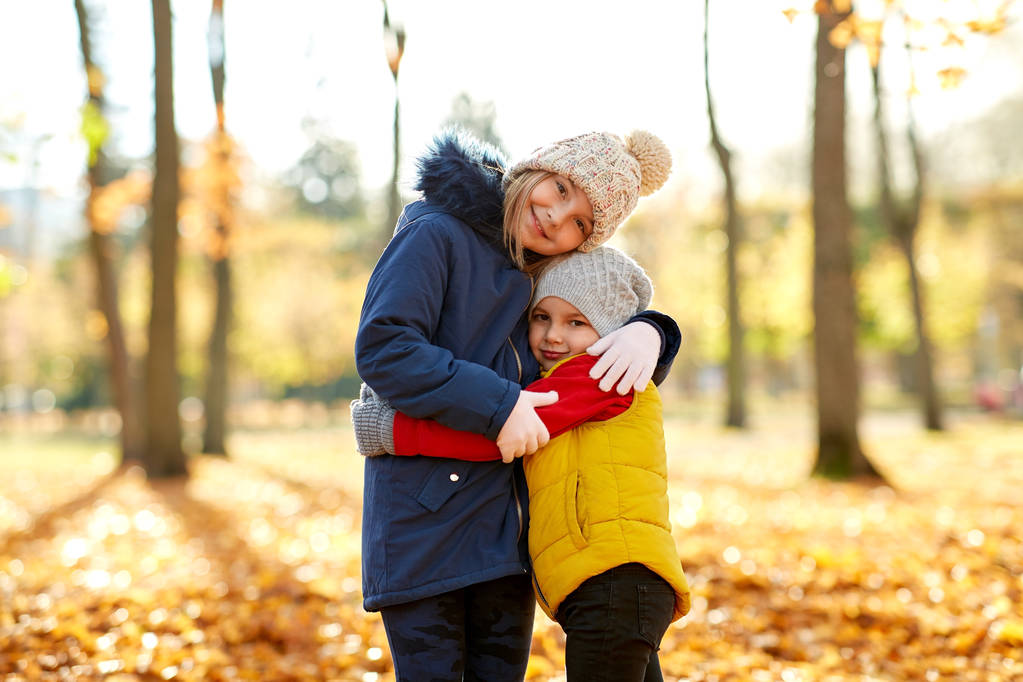 szczęśliwy dzieci przytulanie w parku jesiennym - Zdjęcie, obraz