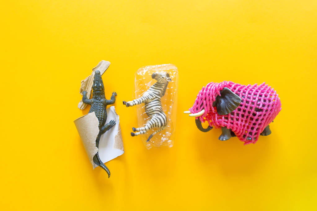 African animal in plastic. Suffering from garbage. Yellow background. - Photo, Image