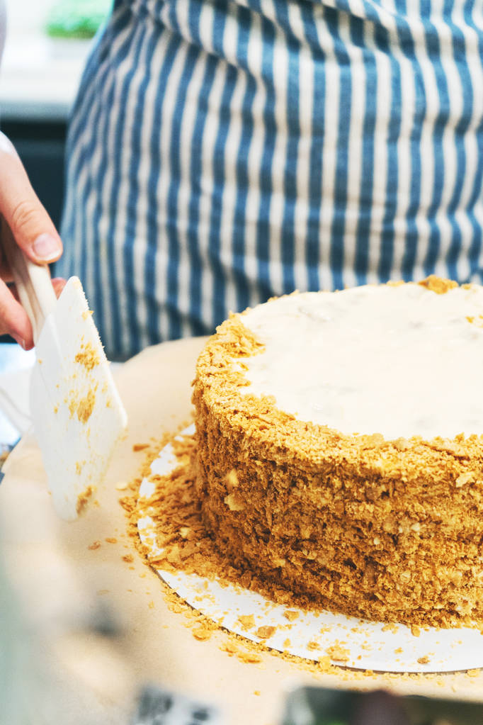 Close view of female pastry chef making sprinkling cake with crumbs - Photo, Image
