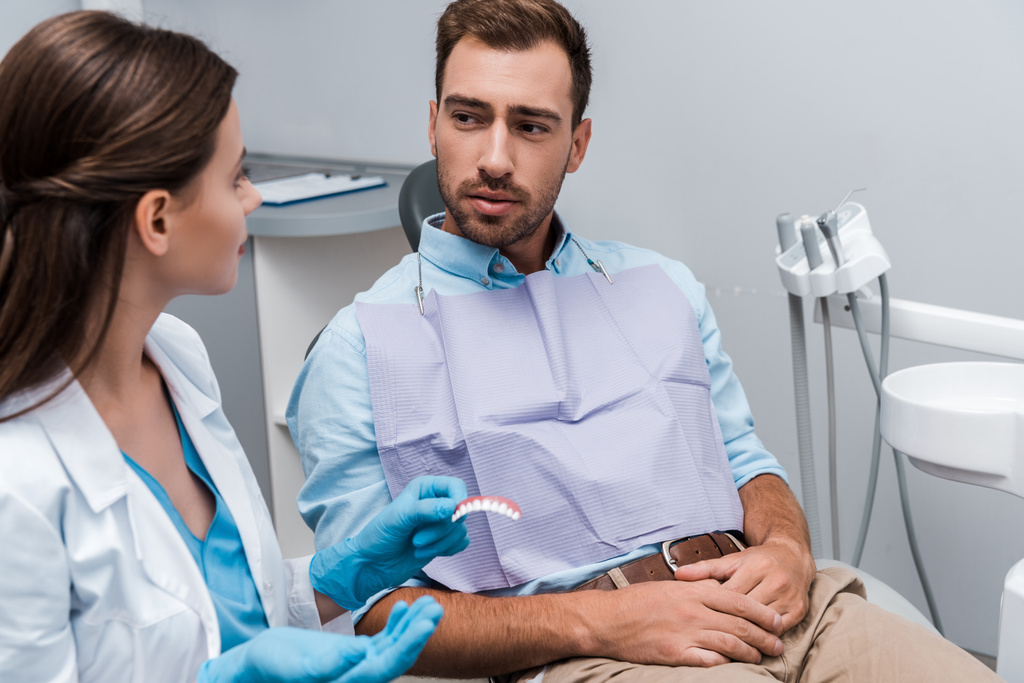 valikoiva painopiste potilaan istuu lähellä hammaslääkäri hampaiden malli klinikalla
  - Valokuva, kuva