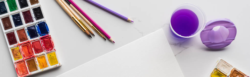 mermer beyaz yüzey üzerinde renkli kalemler ve suluboya boyalar yakın boş beyaz kağıt üst görünümü, panoramik çekim - Fotoğraf, Görsel