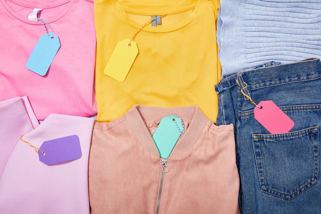 flat lay with paper sale tags on different colorful clothes  - Photo, Image