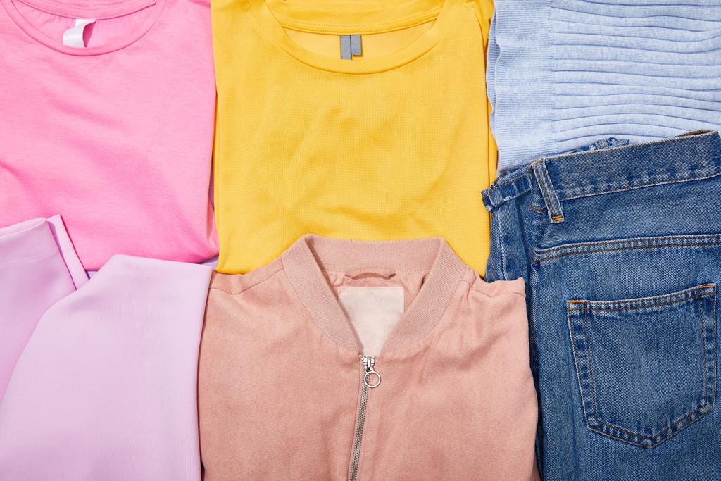 Flat Lay με πολύχρωμα μπλουζάκια, Τζιν, καπέλο και μπουφάν  - Φωτογραφία, εικόνα