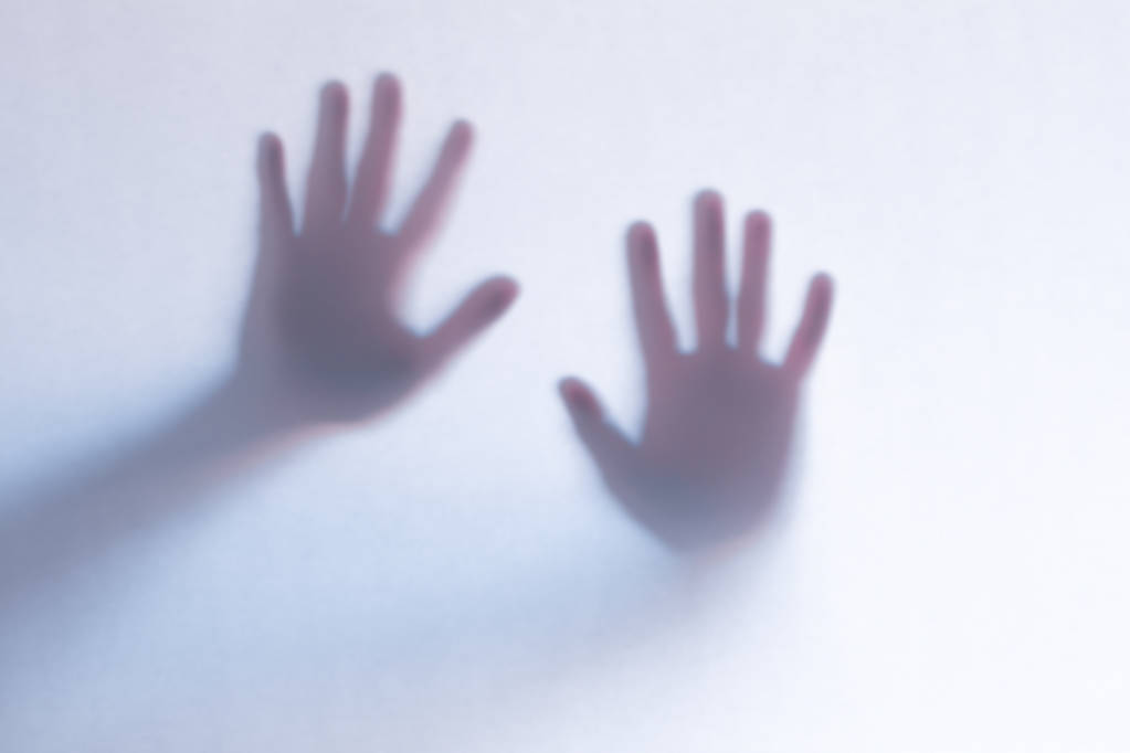 Koncentrált ijesztő szellem keze mögött egy fehér üveg háttér - Fotó, kép