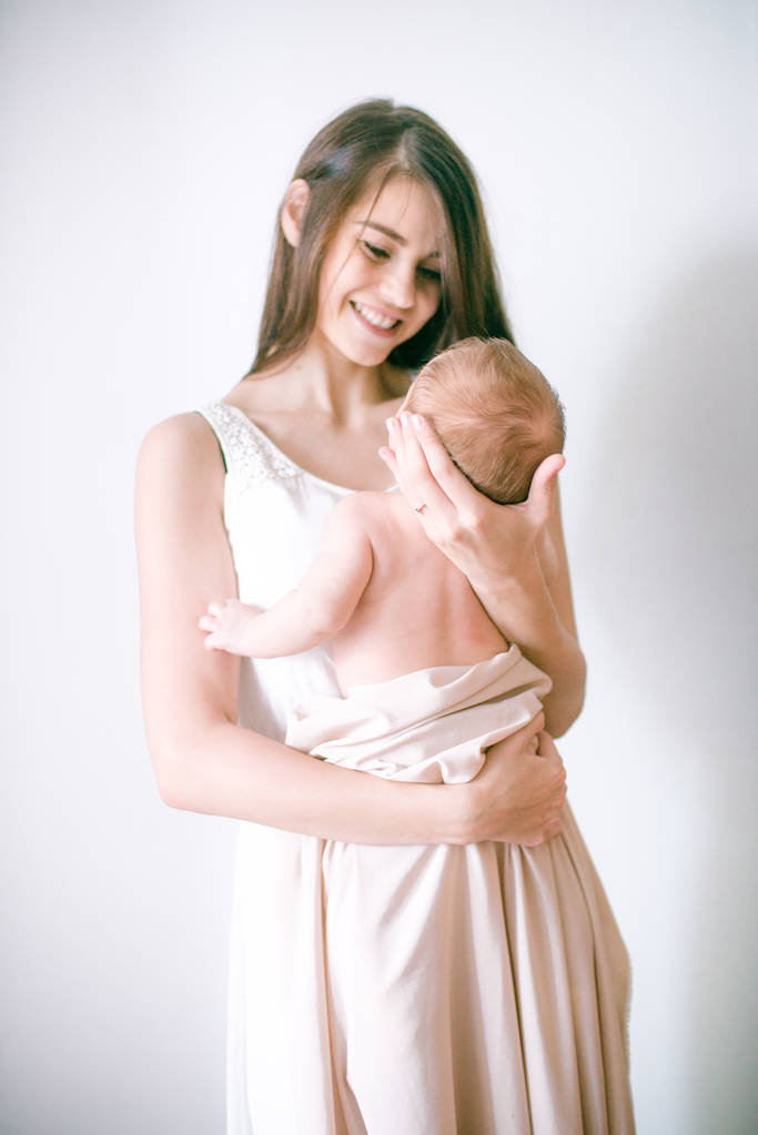 Familien-, Kinder- und Elternschaftskonzept - glücklich lächelnde junge Mutter mit kleinem Baby zu Hause - Foto, Bild