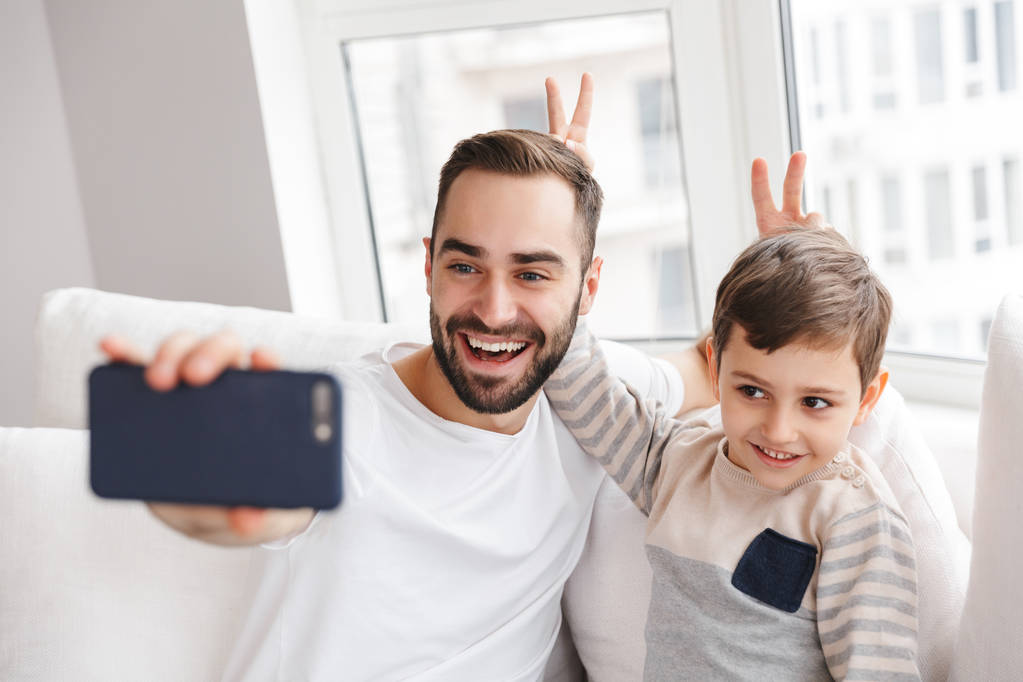 Wesoły ojciec bawią się z synem i robi selfie - Zdjęcie, obraz