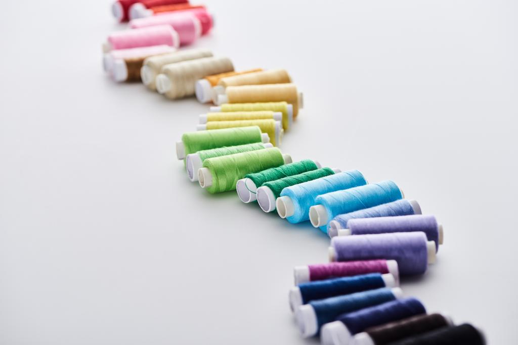 selectieve focus van heldere en kleurrijke draden op witte achtergrond  - Foto, afbeelding