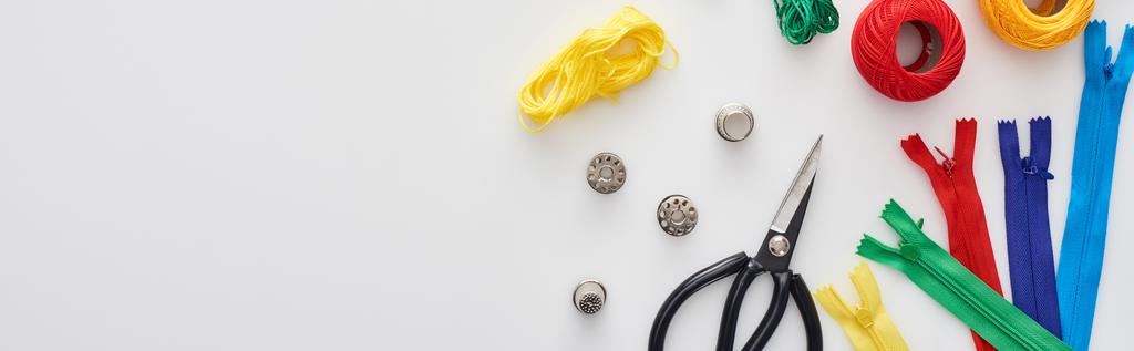 панорамный снимок молний, ножниц, наперстков, нитей, вязальных пряжи шарики, бобины на белом фоне
  - Фото, изображение