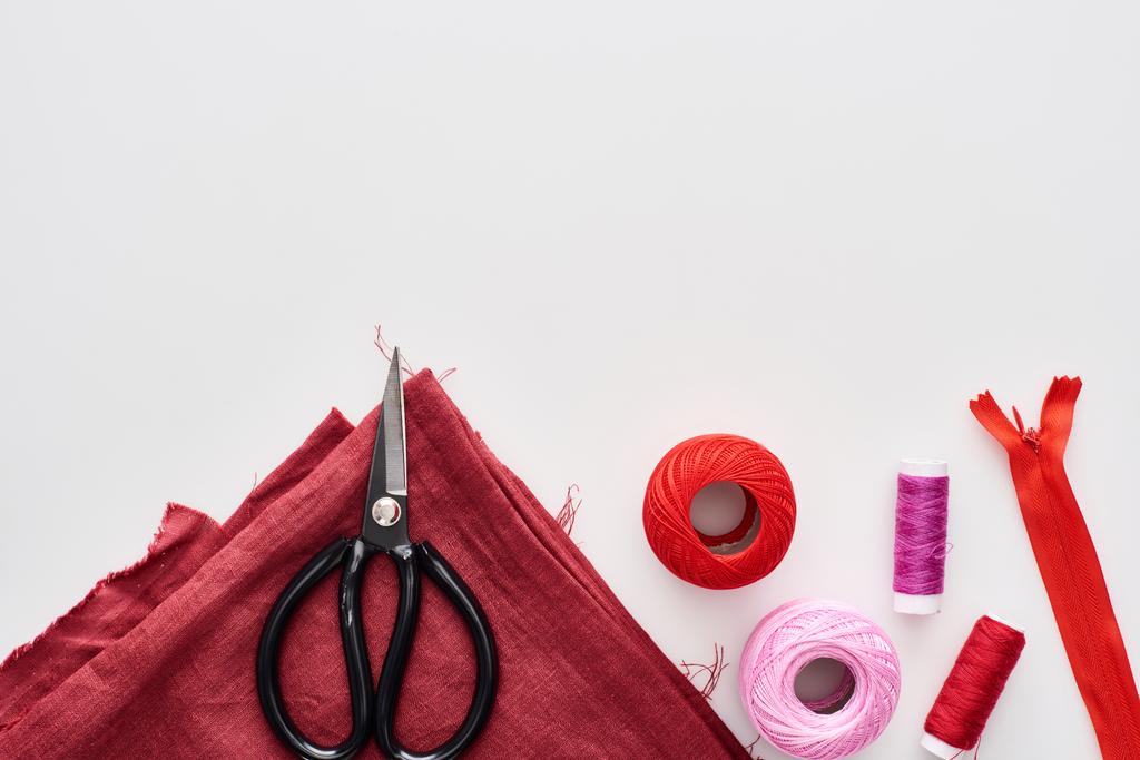 top view of colorful threads, knitting yarn balls, fabric, scissors and zipper on white background  - Photo, Image