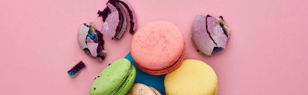 top view of multicolored delicious French macaroons in blue postal envelope on pink background, panoramic shot - Photo, Image