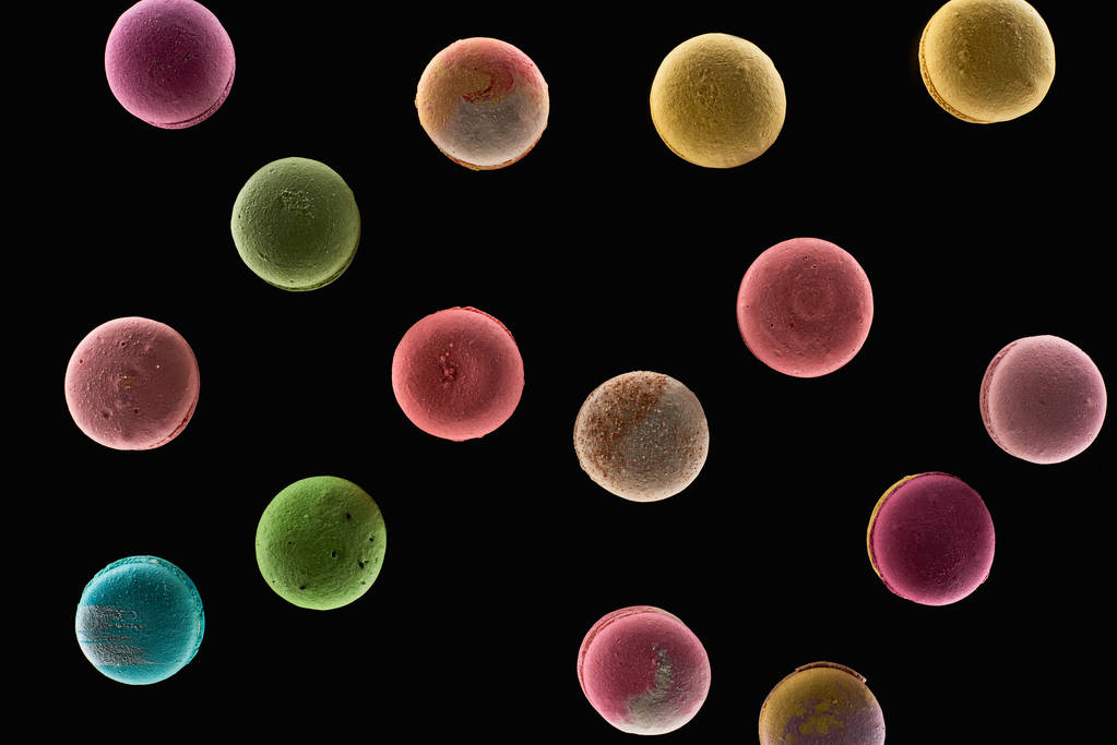pohled na lahodné barevné francouzské makaroony různých příchutí izolovaných na černém - Fotografie, Obrázek
