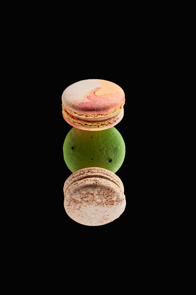 вид сверху на три вкусных красочных французских макарон различных вкусов, изолированных на черном
 - Фото, изображение