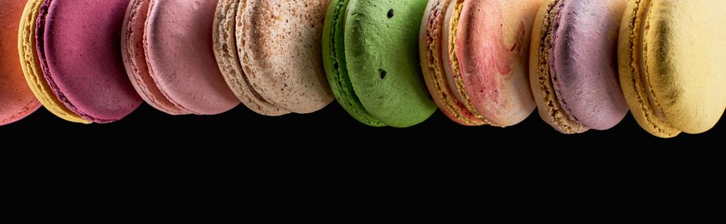 rząd smaczne kolorowe francuskie makaroniki różnych smakach izolowane na czarno z kopią przestrzeni, panoramiczny strzał - Zdjęcie, obraz