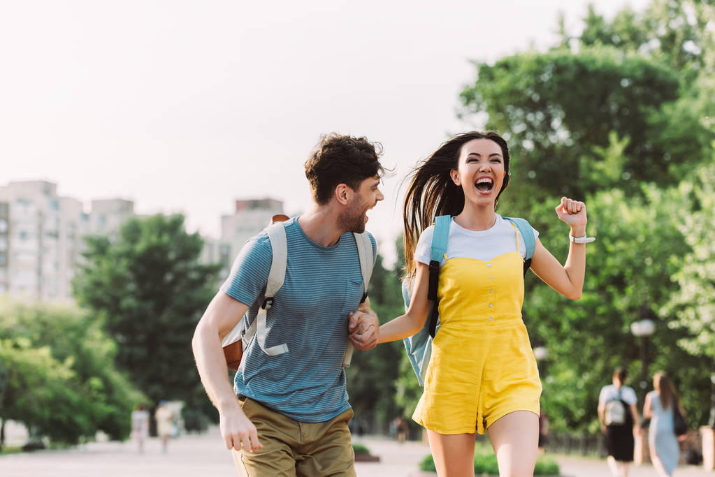 przystojny mężczyzna i Asian kobieta bieganie i patrząc od  - Zdjęcie, obraz
