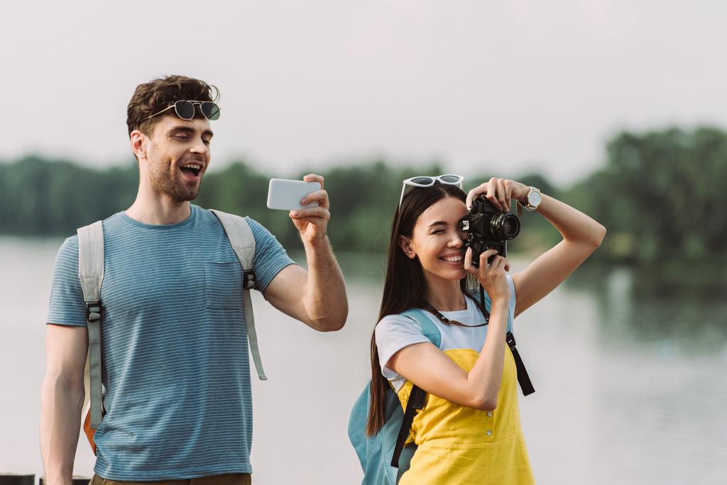 asian woman taking photo and handsome man using smartphone  - Photo, Image