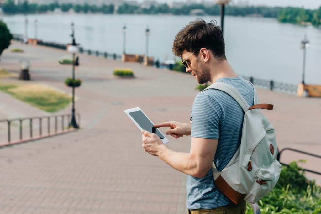 handsome man in glasses with backpack using digital tablet  - Photo, Image