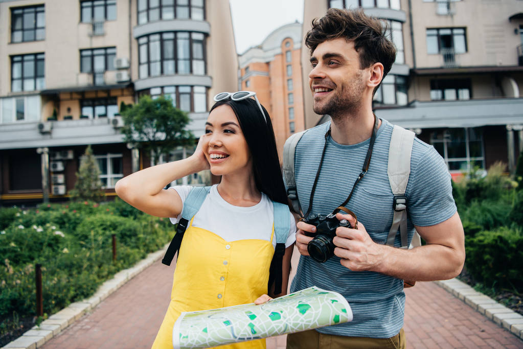 jóképű férfi digitális fényképezőgép és az ázsiai nő a Térkép elnéz  - Fotó, kép