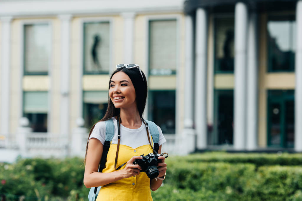 atraktivní a asijská žena s digitálním fotoaparátem, který hledí jinam  - Fotografie, Obrázek