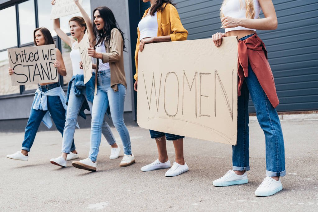 bijgesneden beeld van feministen die plakkaat met woord vrouwen op straat houden - Foto, afbeelding