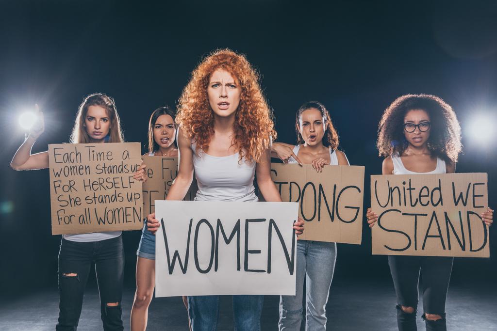 attraktive multikulturelle Mädchen stehen und halten Plakate mit Schriftzug auf schwarz   - Foto, Bild