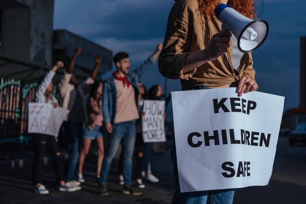 nyírt kilátás lány gazdaság plakát és tartsa gyermekek biztonságos betűkkel közelében multikulturális emberek ülésén  - Fotó, kép