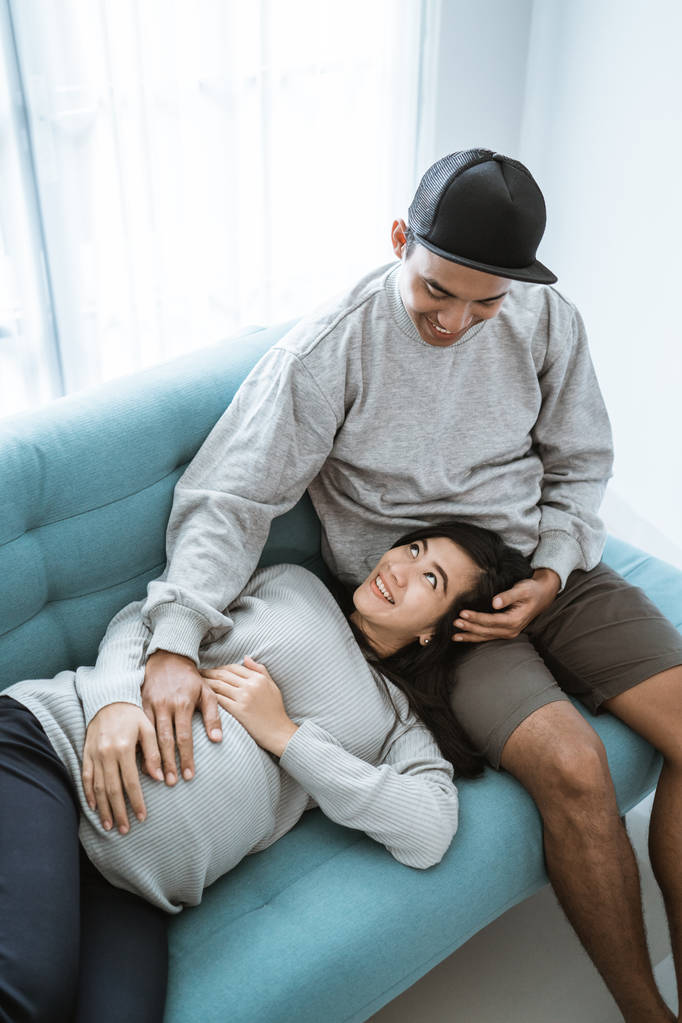 hamile bir karısı dinlenirken kocası kucağında yatıyor - Fotoğraf, Görsel