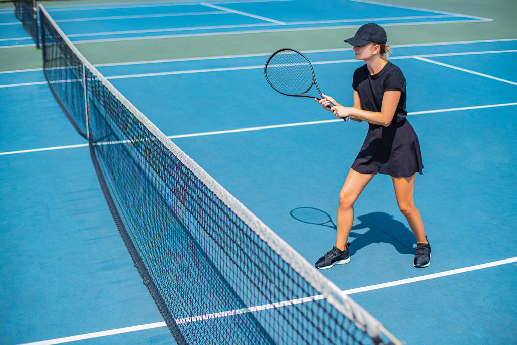 Young sports woman playing tennis on the blue tennis court - Photo, Image