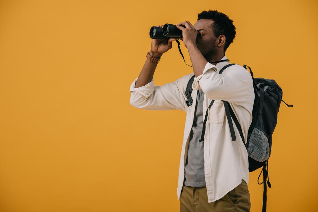 afro-amerikai férfi keres keresztül binokuláris elszigetelt narancs  - Fotó, kép