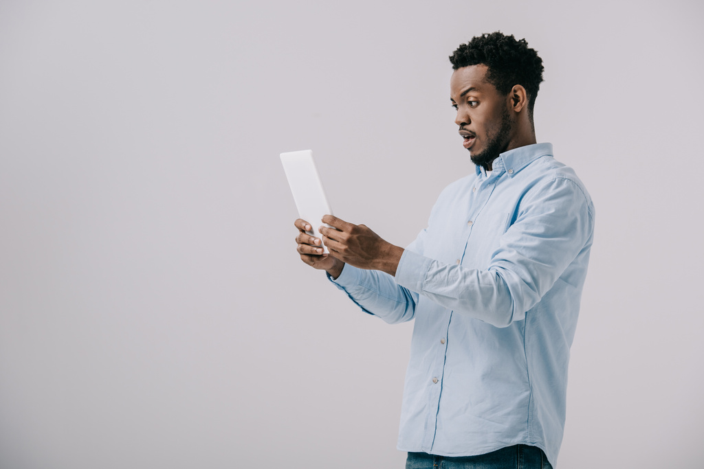 African amerykański człowiek trzymanie tabletka cyfrowa izolowane na szary  - Zdjęcie, obraz