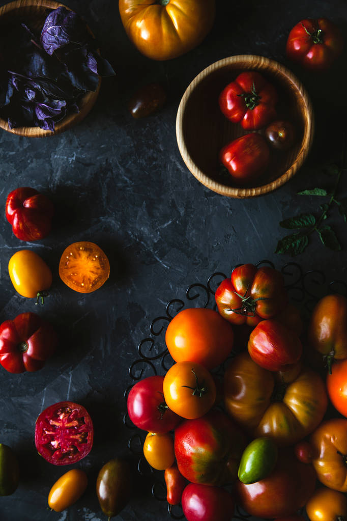 Složení s lahodnou rajčaty, dřevěnou desku a výrobky na šedém pozadí, zdravé jídlo - Fotografie, Obrázek