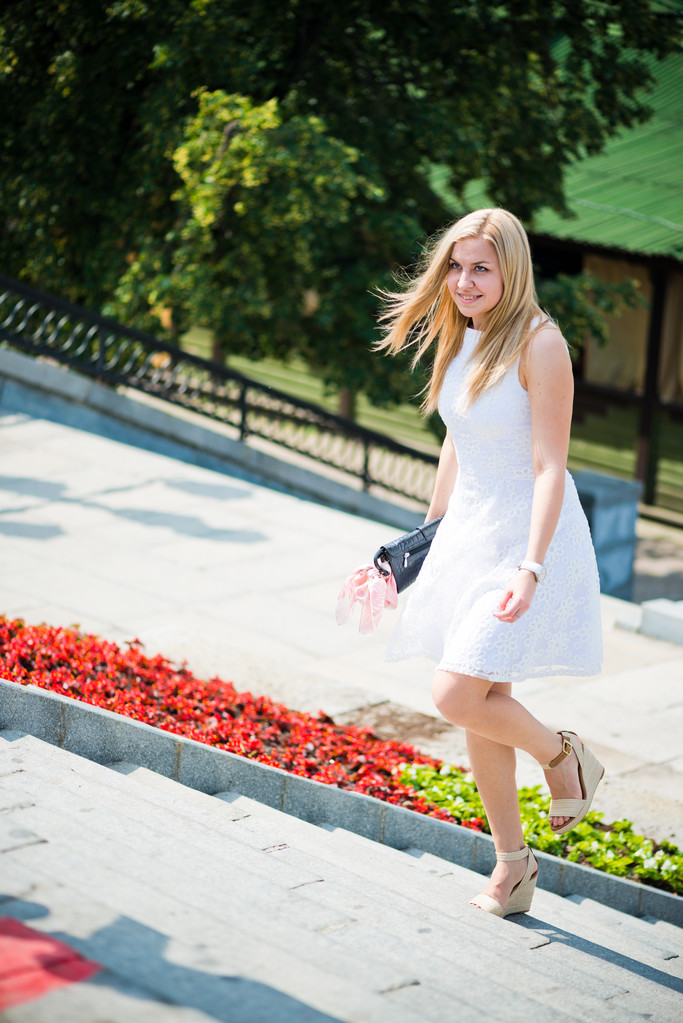 Beautiful blond woman walking upstairs outdoors - Photo, Image