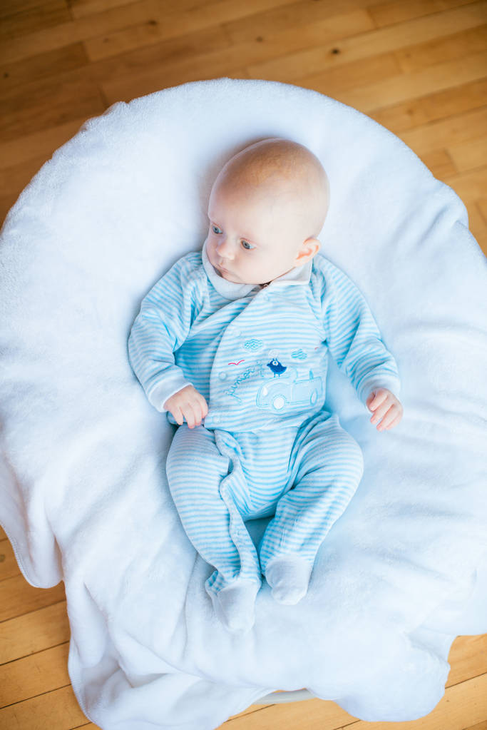 Adorable bebé en el dormitorio blanco y soleado. Niño recién nacido relajándose en la cama. Guardería infantil para niños pequeños. Textil y ropa de cama para niños. Mañana familiar en casa
 - Foto, imagen