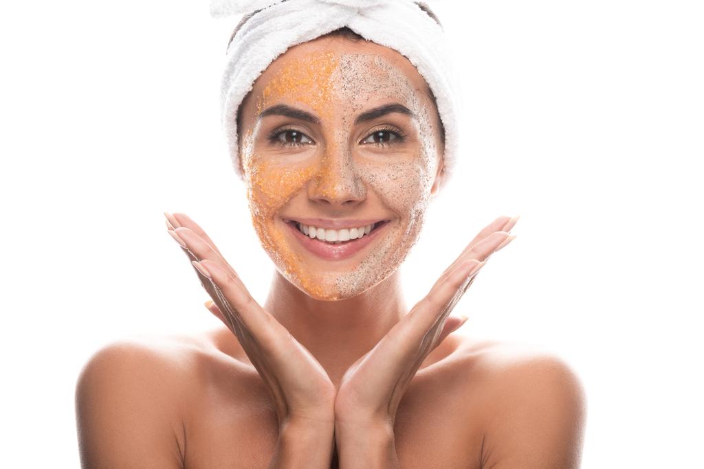 vista frontale di eccitata giovane donna in fascia cosmetica con scrub sul viso isolato su bianco
 - Foto, immagini