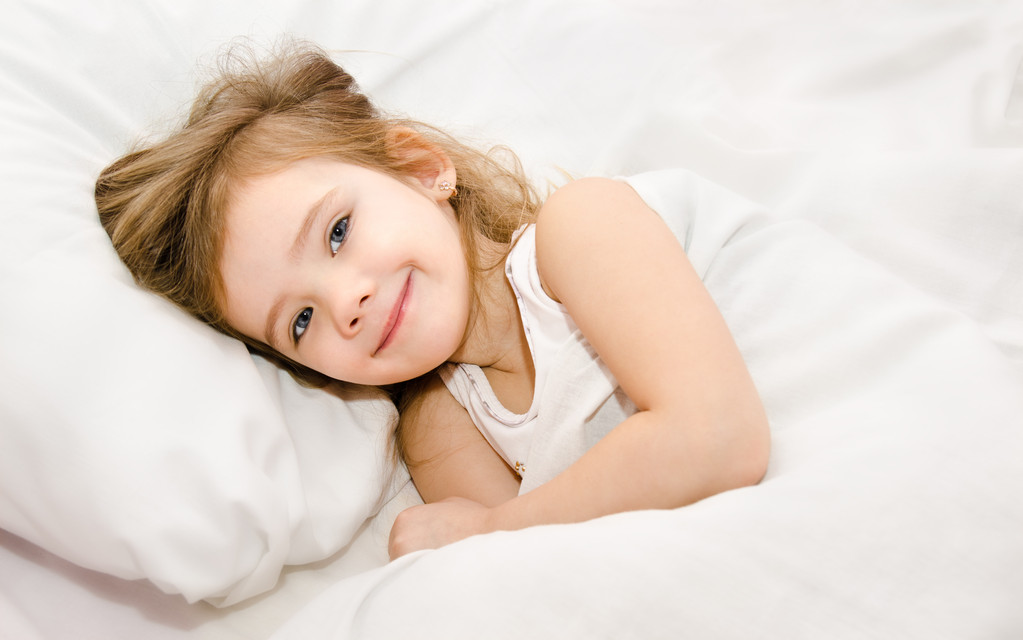 Adorabile bambina svegliata nel suo letto
 - Foto, immagini