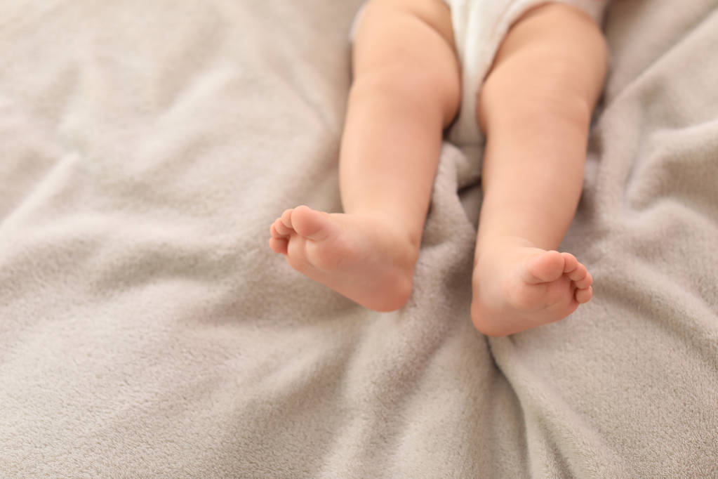 かわいい赤ちゃんがベッドに横たわって、足のクローズアップ。テキスト用のスペース - 写真・画像