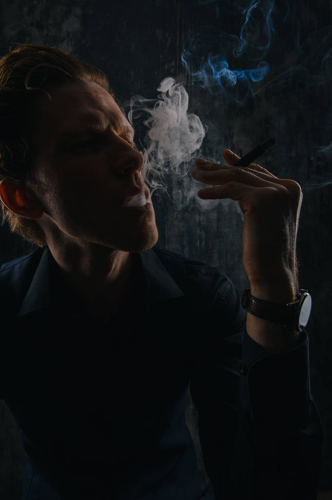 Brutal Mistério homem com charuto e fumaça isolado no fundo preto
 - Foto, Imagem