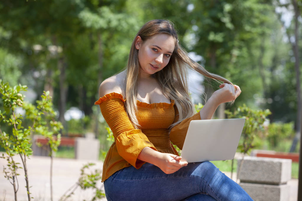 mladá žena s laptopem na zelené trávě v parku - Fotografie, Obrázek