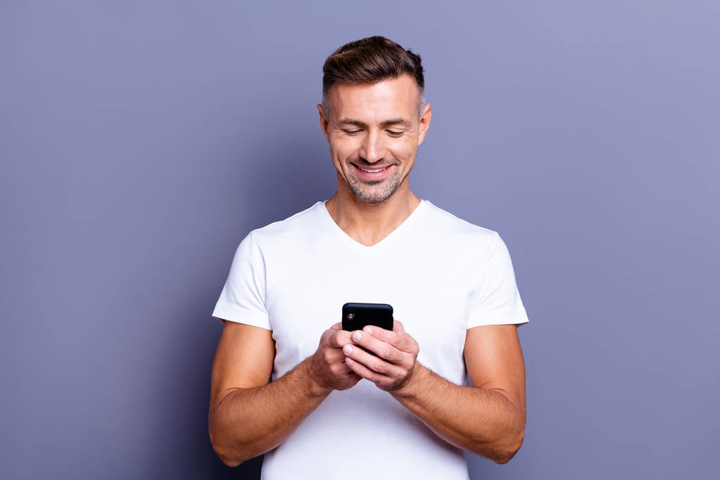 Close up photo amazing he him his middle age macho perfect appearance easy-going funky person telephone hands arms read instagram followers post wear casual white t-shirt isolated grey background - Photo, Image