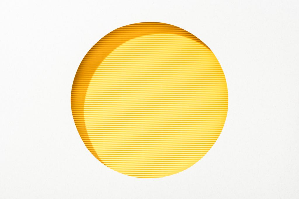 cut out round hole in white paper on striped yellow colorful background - Photo, Image