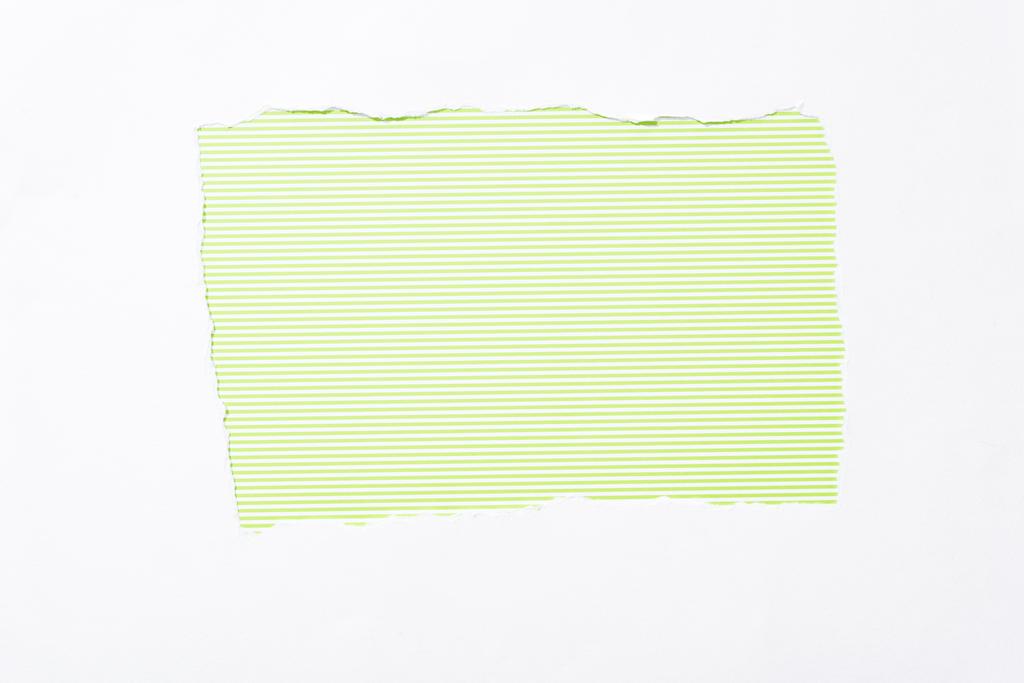 Lime groen gestreepte kleurrijke achtergrond in wit gescheurd papier gat - Foto, afbeelding