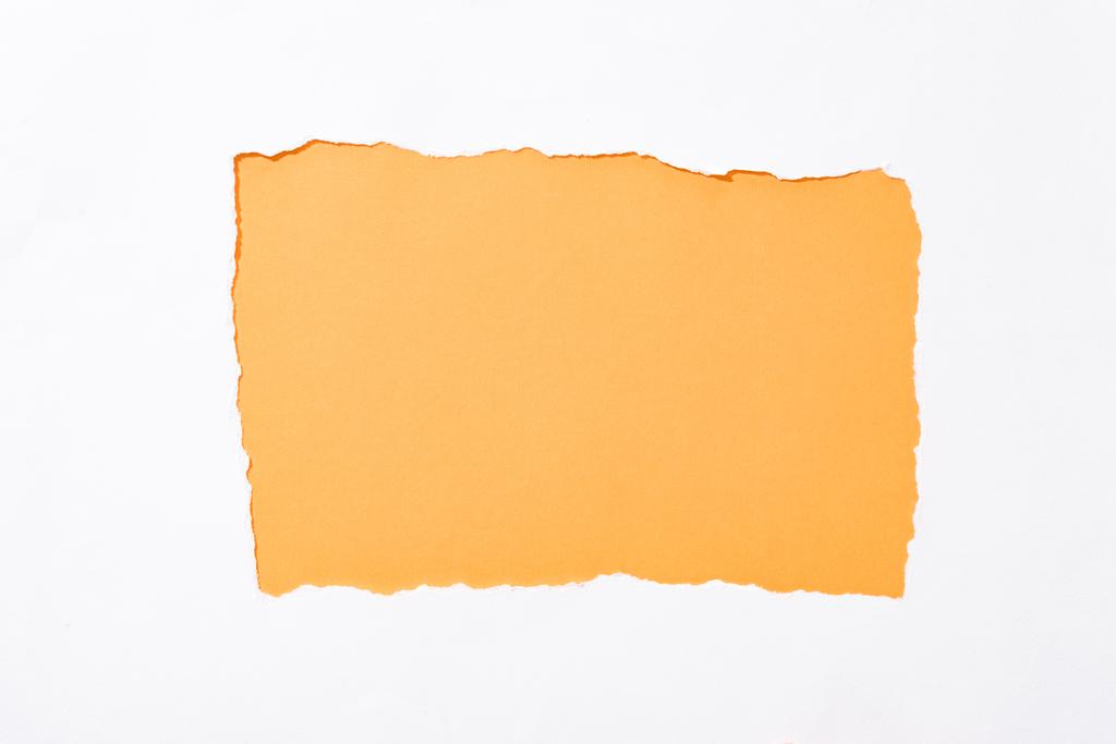 Oranje kleurrijke achtergrond in wit gescheurd papier gat - Foto, afbeelding