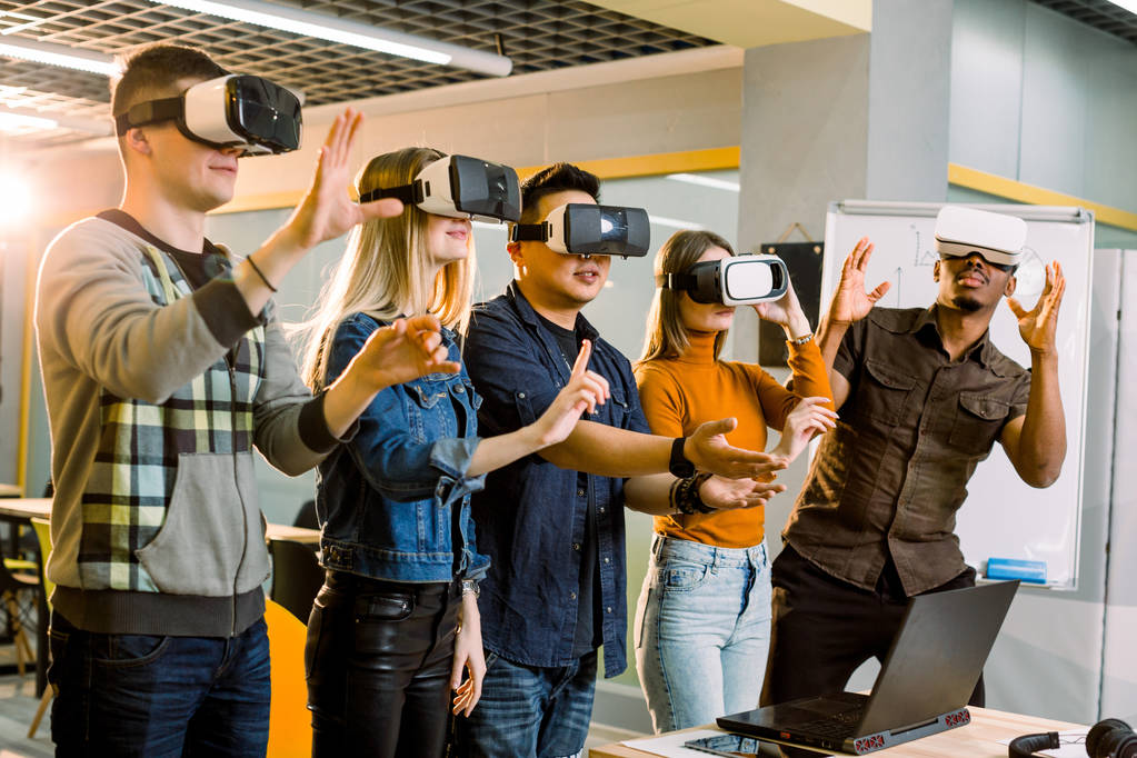Sorprendió a cinco jóvenes freelancers compañeros de trabajo tocando el aire durante la experiencia VR. Disparo horizontal
. - Foto, Imagen