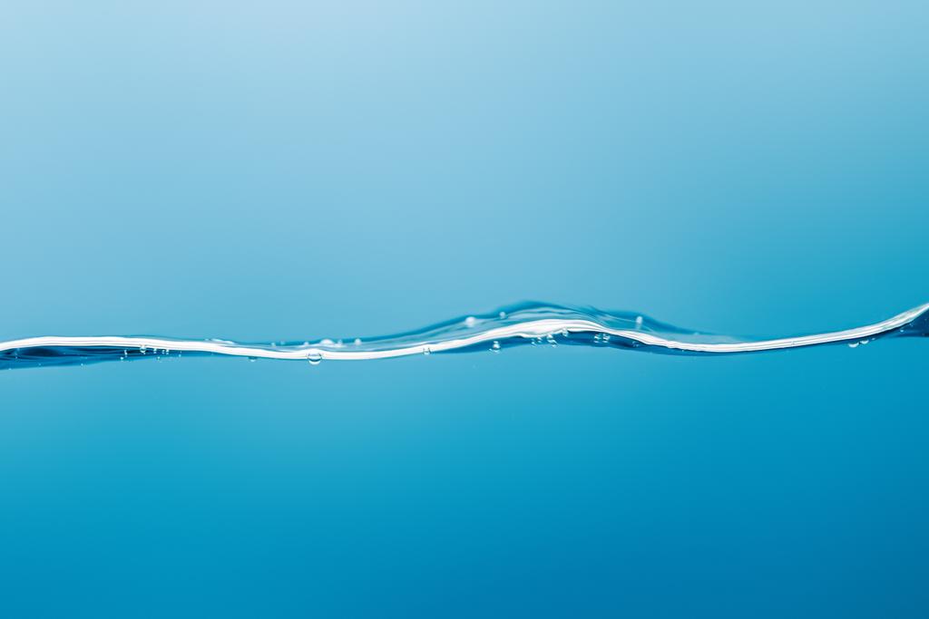 transparante zuivere water Golf met druppels op blauwe achtergrond - Foto, afbeelding