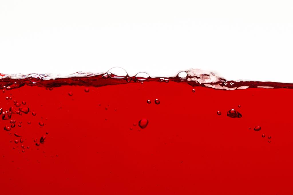 líquido colorido vermelho com bolhas na superfície isolado no branco
 - Foto, Imagem