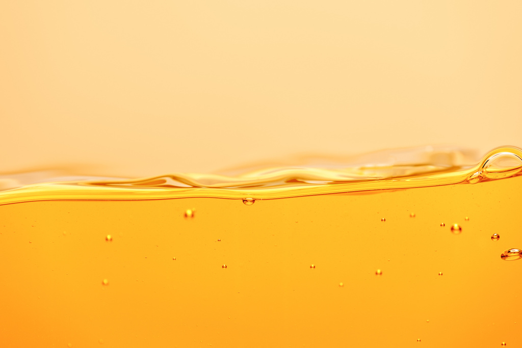wellige gelbe helle Flüssigkeit mit Spritzer und Blasen isoliert auf gelb - Foto, Bild