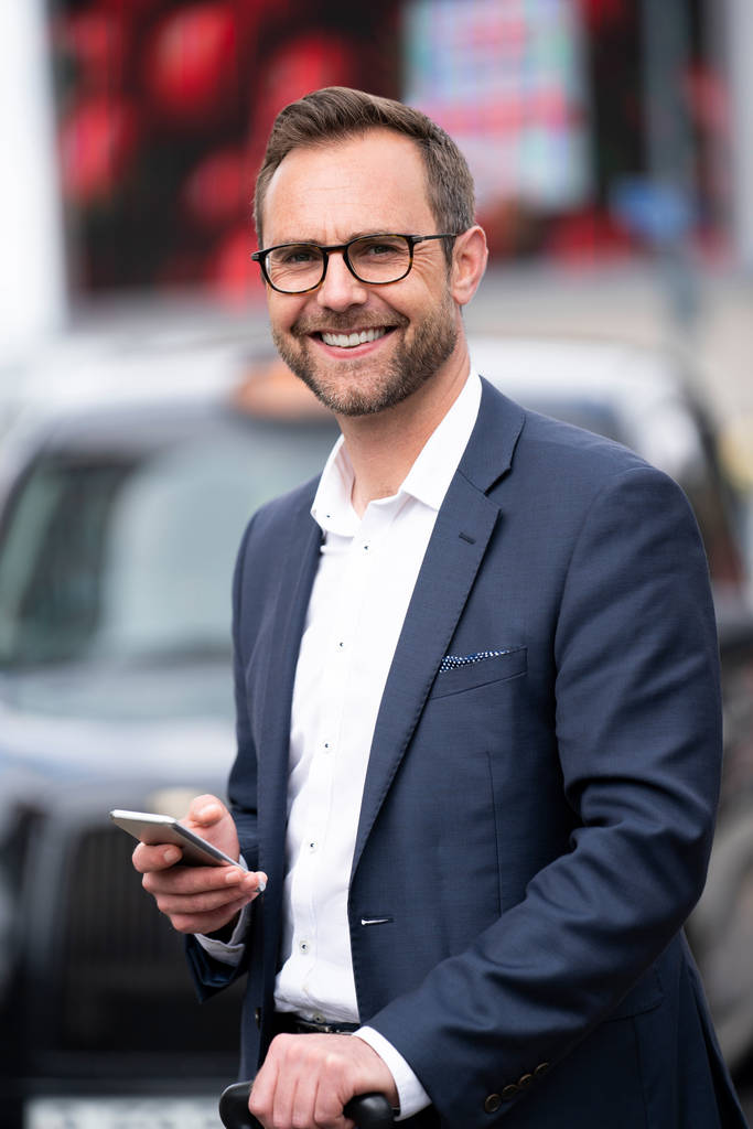 Retrato de empresário maduro com móvel em pé pela classificação de táxi
 - Foto, Imagem